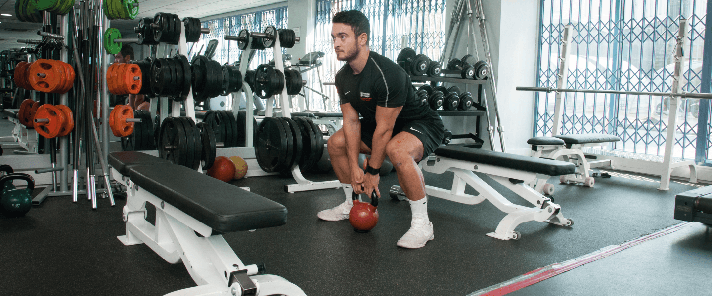 Person in the gym using kettlebells