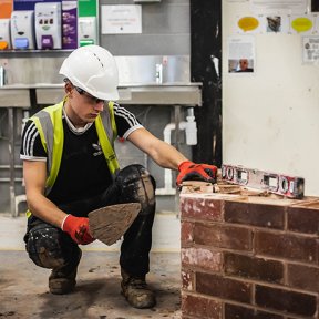 Student working on building a brick wall.