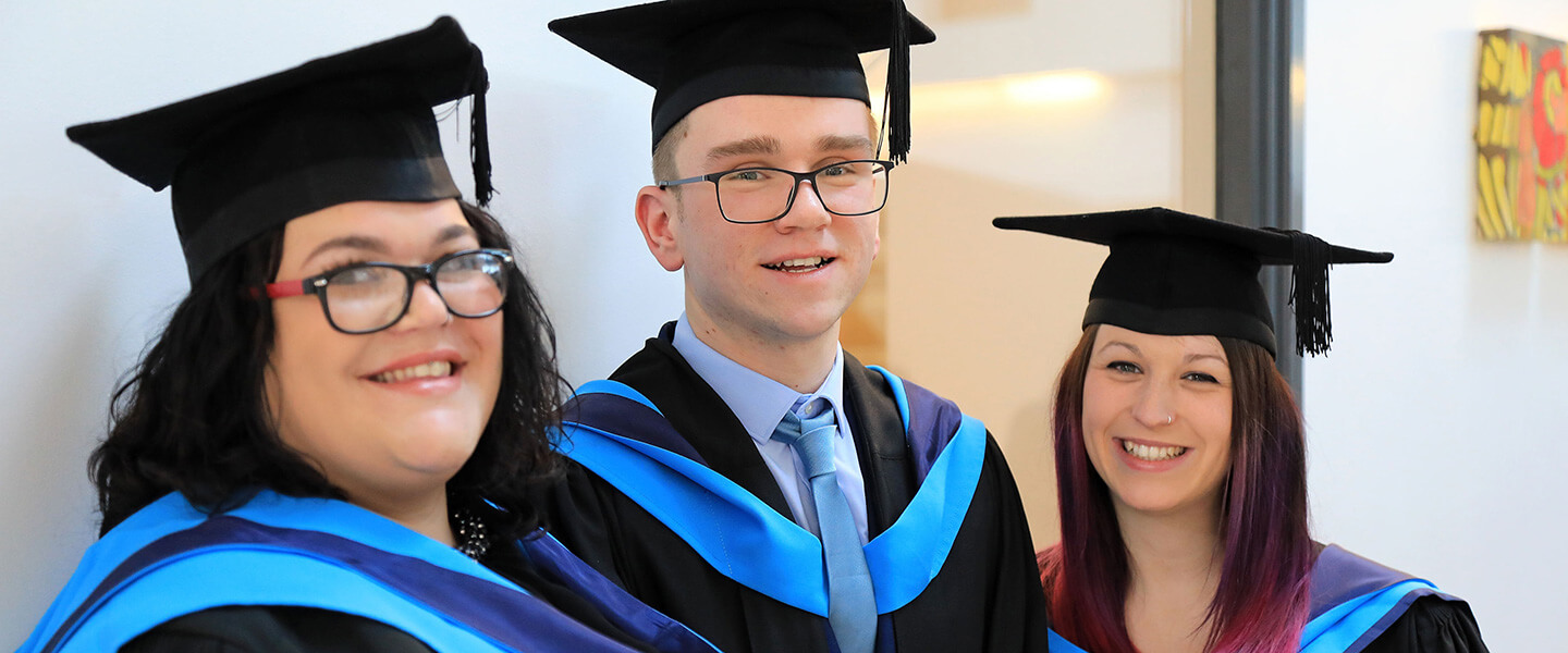 Three Graduands in academic dress at Graduation