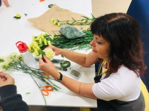 woman creating floral arrangement