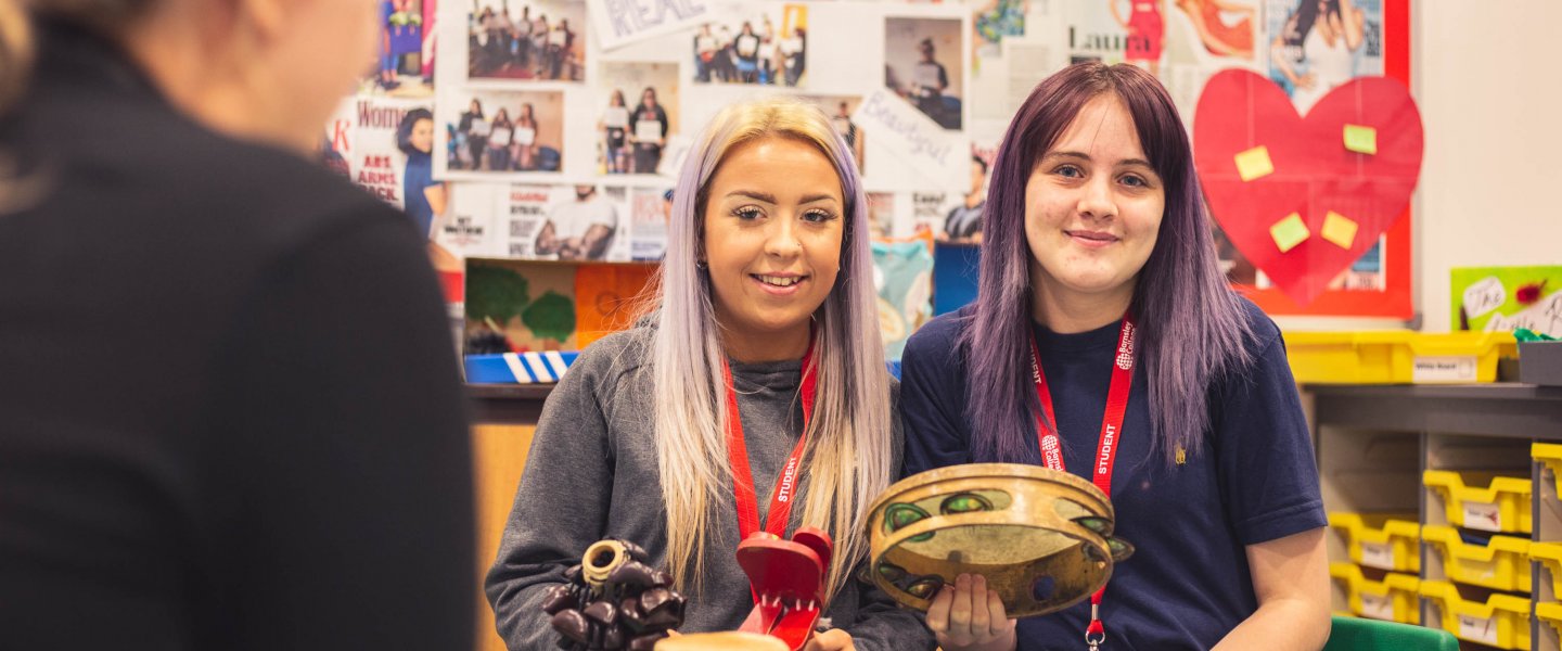 Barnsley College's Education and Childcare students holding musical instruments