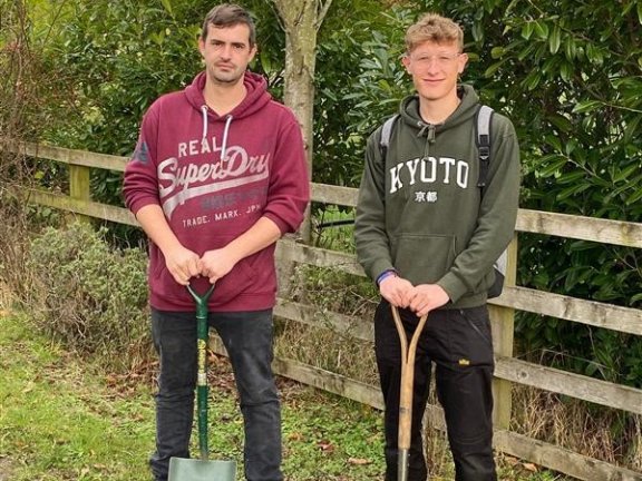 Two Barnsley College Horticulture students with gardening equipment.