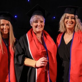 three graduates smiling