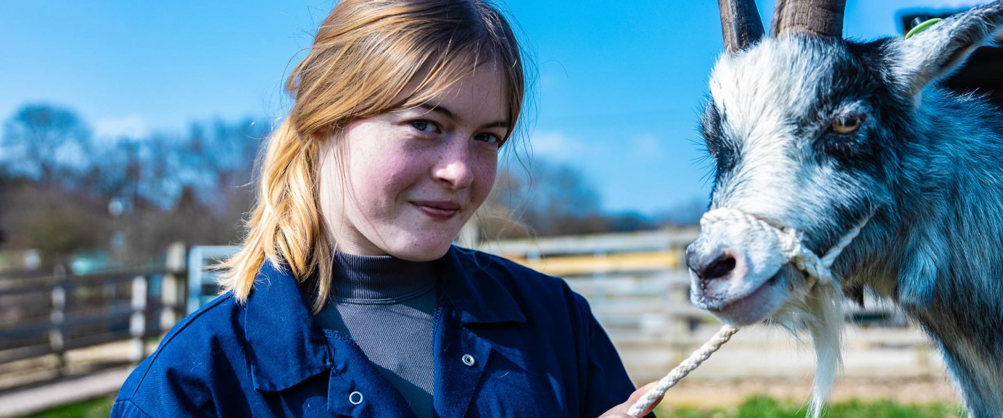 student smiling with goat