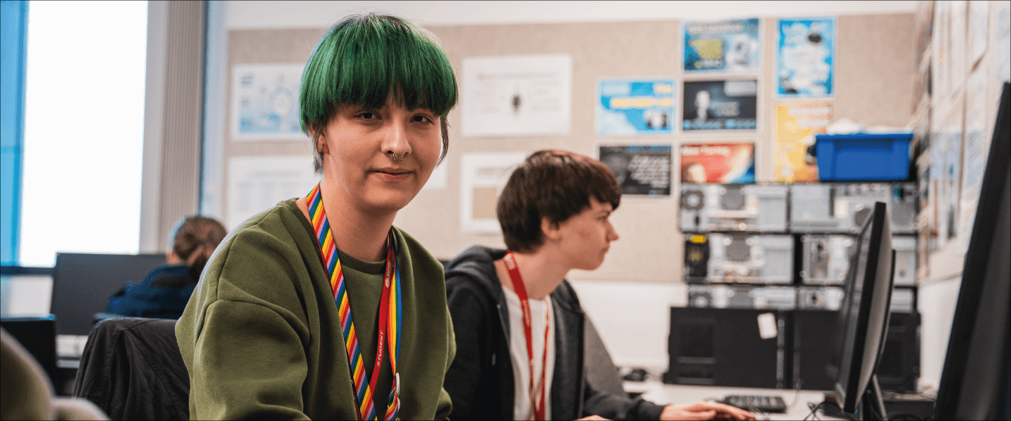 a girl with short green hair smiles at the camera
