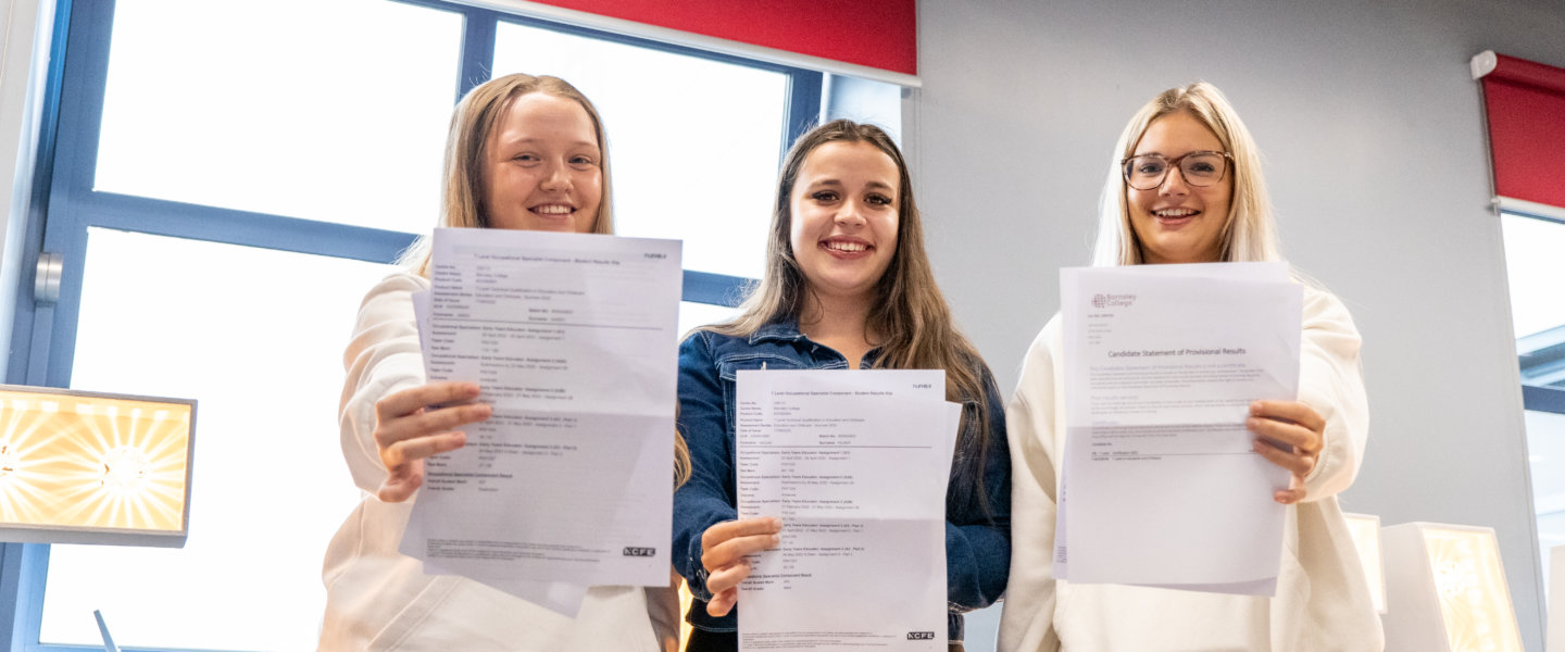 students smiling with holding papers