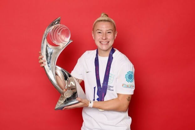 person smiling holding trophy