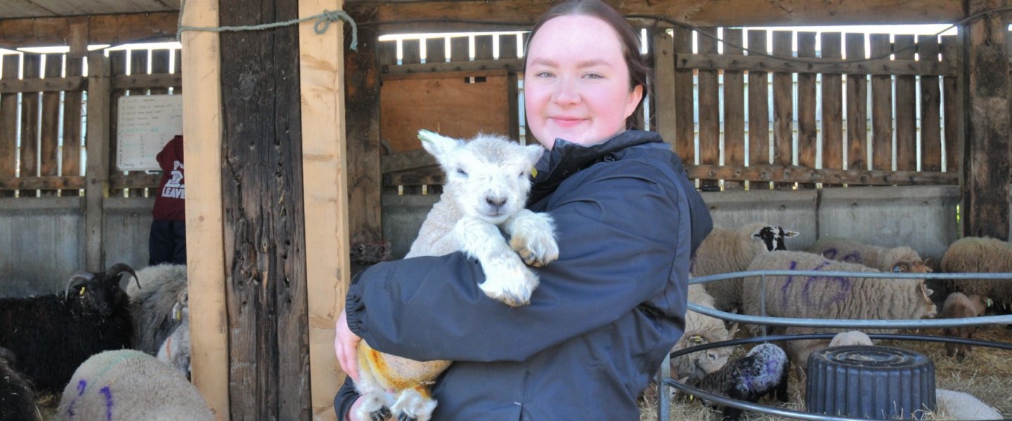 Higher Education student Eliza with Dolly the lamb