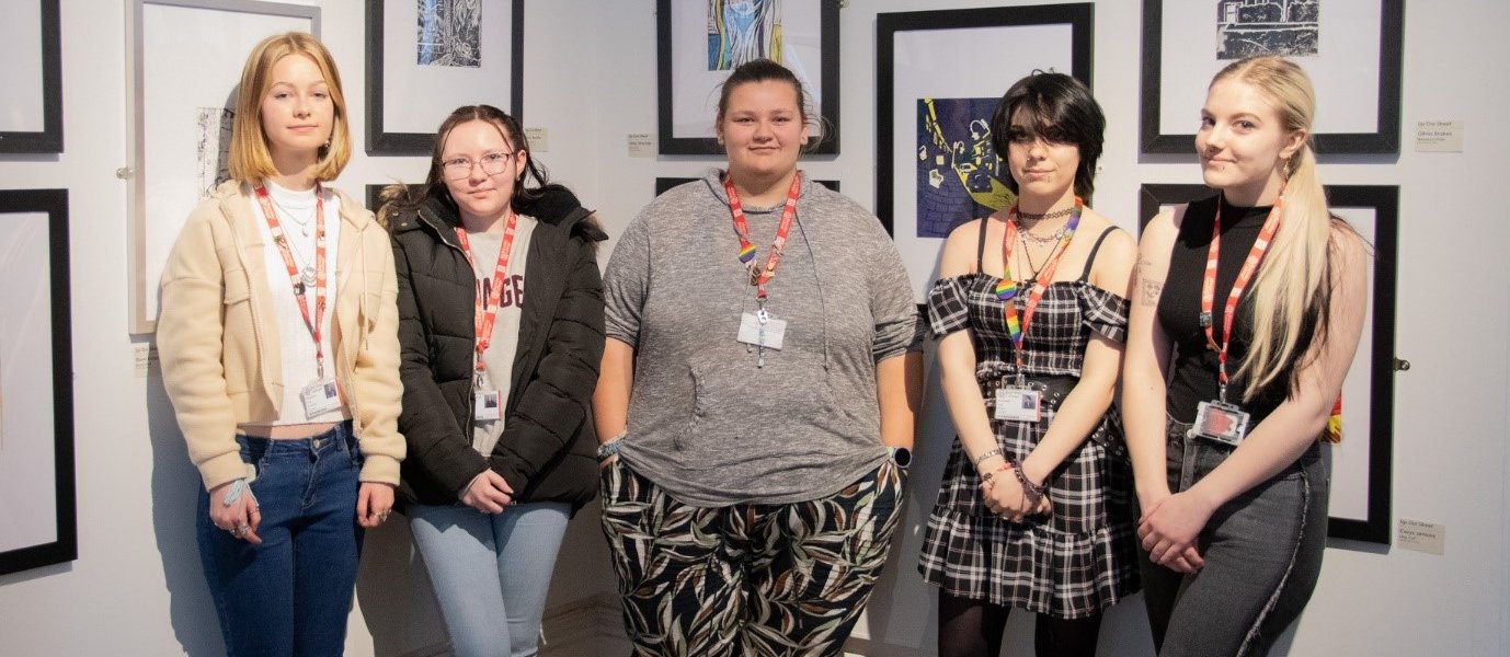 Five Barnsley College students stood in front of their artwork.
