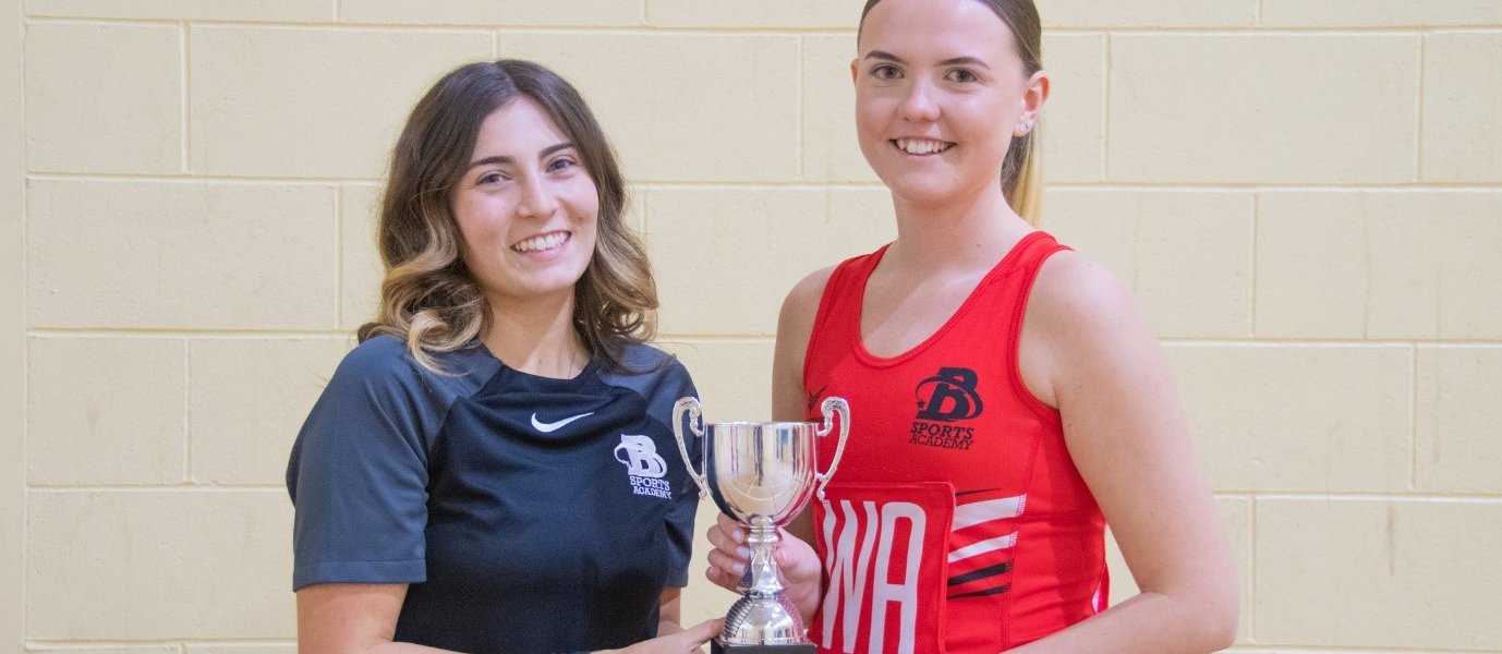 Netball Coach, Chloe White and Netball Captain, Hannah Cooper. holding a trophy.