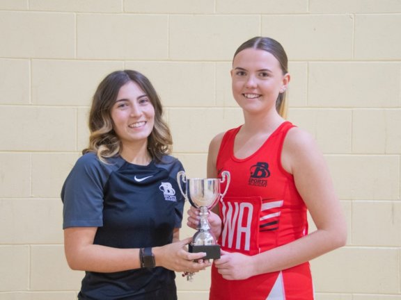 Netball Coach, Chloe White and Netball Captain, Hannah Cooper. holding a trophy.