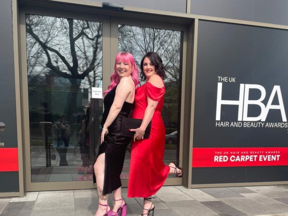Holly Oldfield and her employer, Natalie Palmowski, dressed up and posing outside the UK Hair and Beauty Awards 2023 red carpet final event.