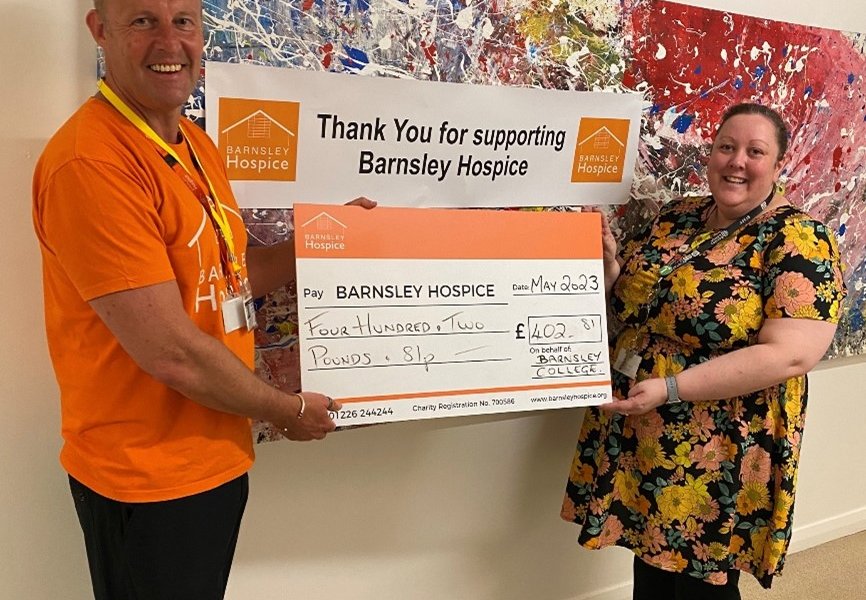 Barnsley College Tutorial Team Leader Vicky Kenny handing over College’s donation to Simon Atkinson from Barnsley Hospice