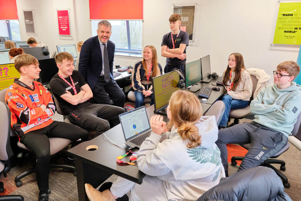 Mayor of South Yorkshire Oliver Coppard speaks with Barnsley College students in a classroom.