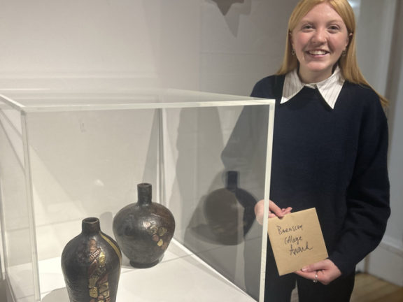 Isabel Edwards stood smiling with her winning ceramics.